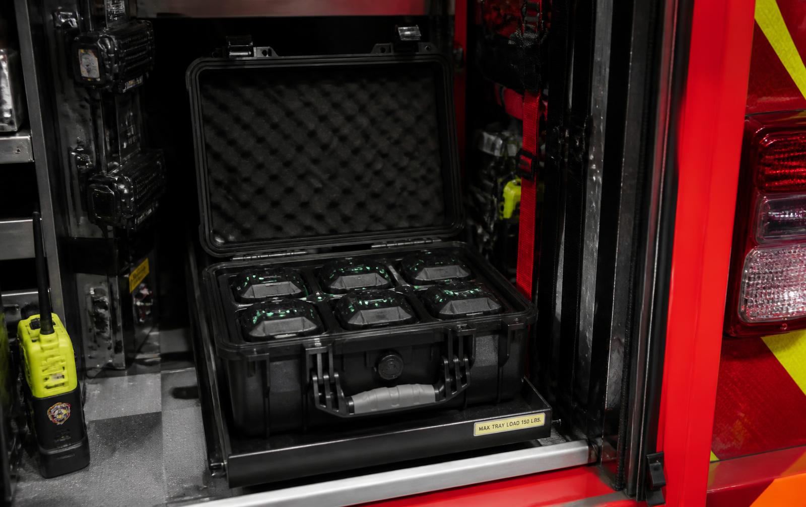 Fire apparatus on scene with responders staging portable sensing equipment